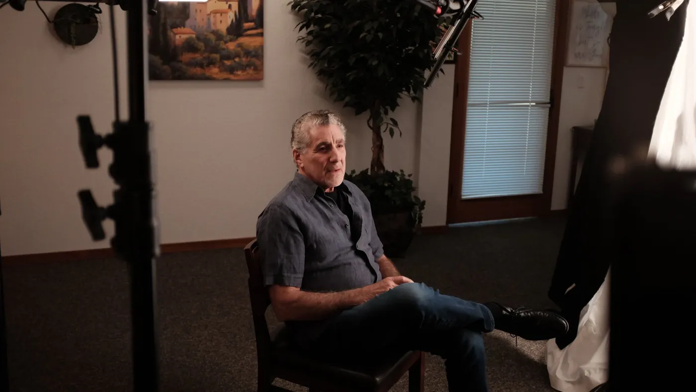 A man seated for an on-camera interview