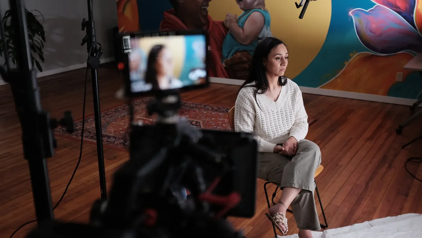 A woman being interviewed, with the camera and monitor in the foreground