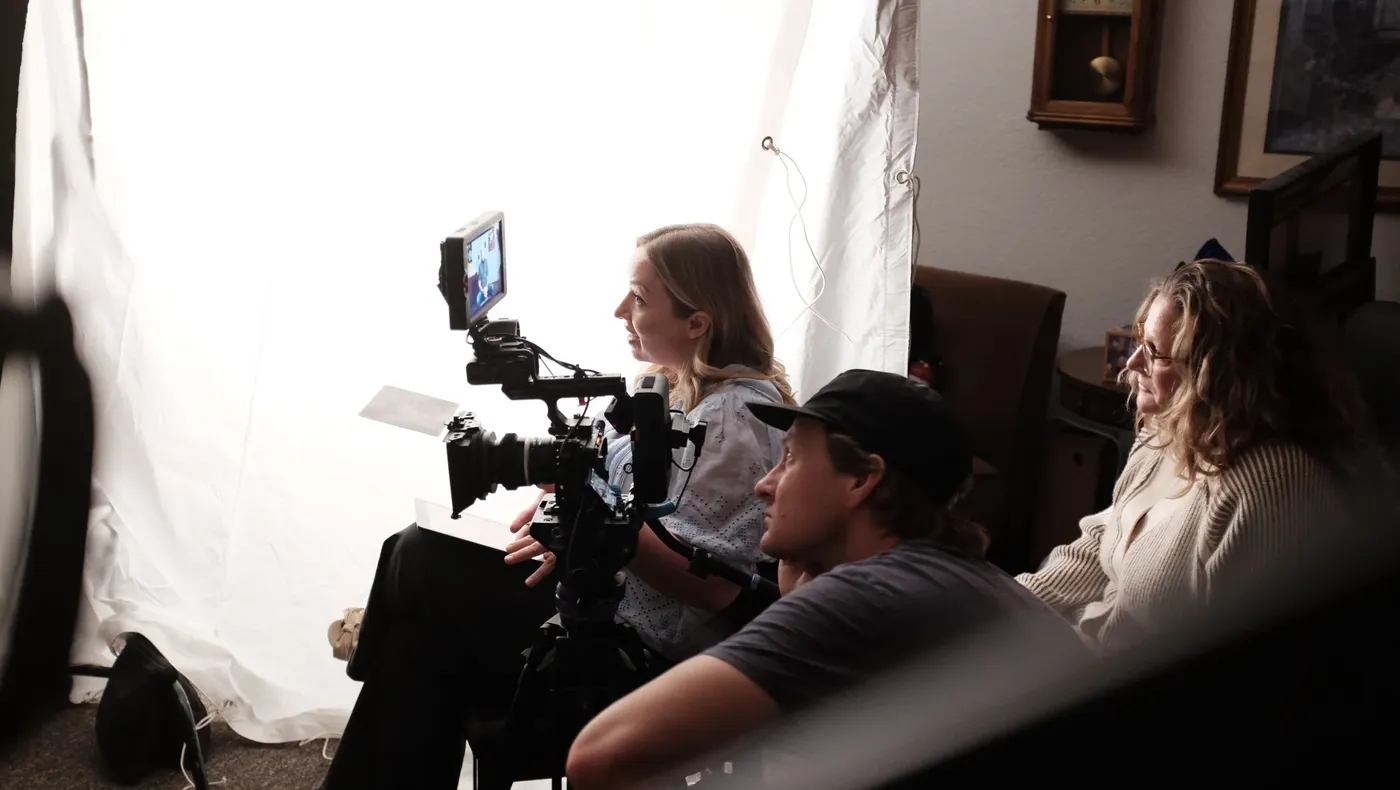 The crew filming an interview in front of a white backdrop
